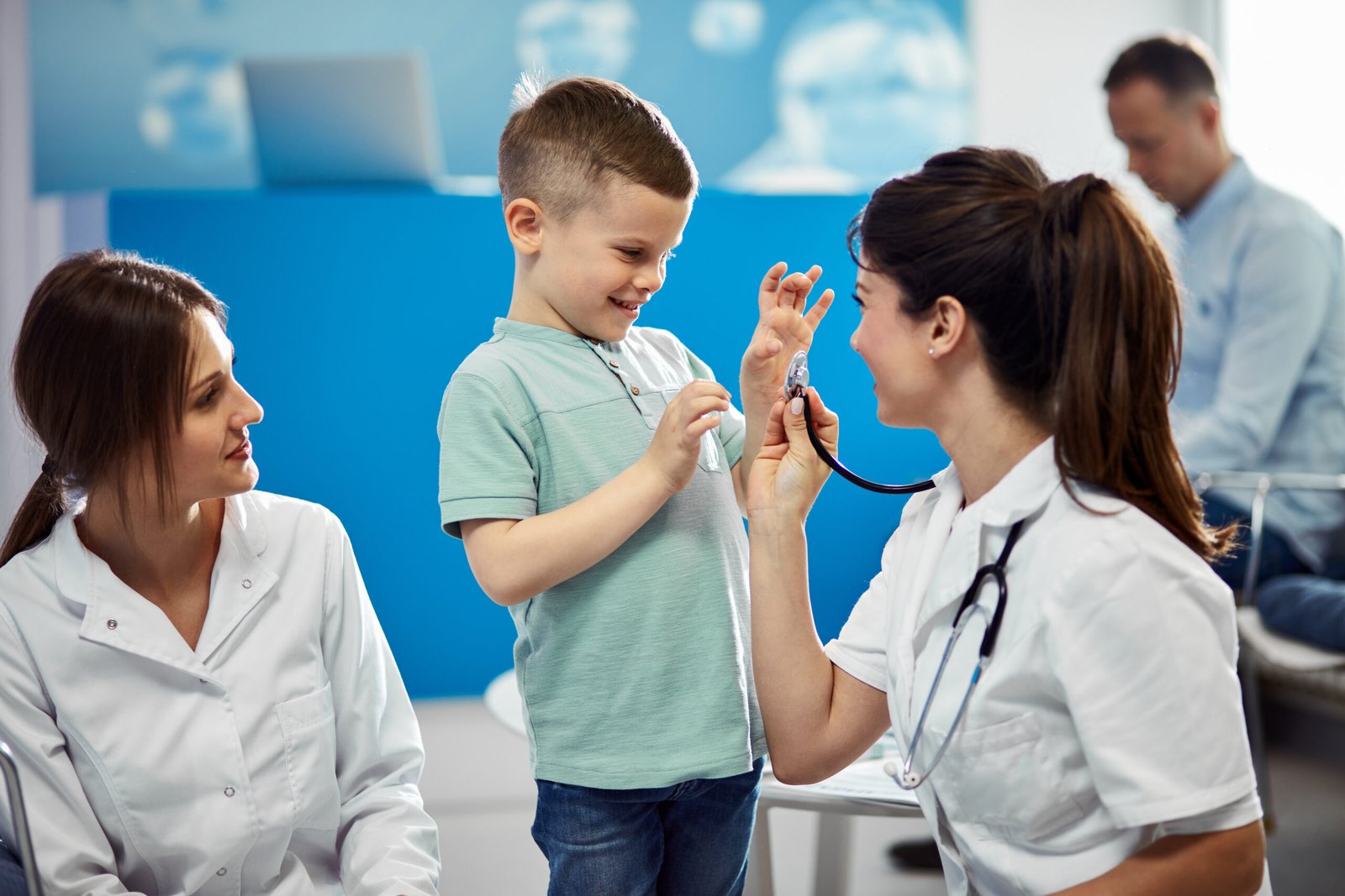Happy boy having fun with pediatrician during medical appointment at doctor's office.