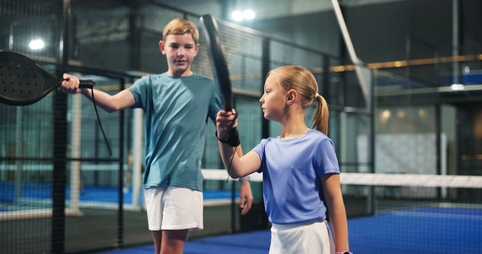Padel, learning and kids with racket on indoor court for sports workout, exercise and training. Fitness club, siblings and boy with girl for playing game, match and tournament for practice together.